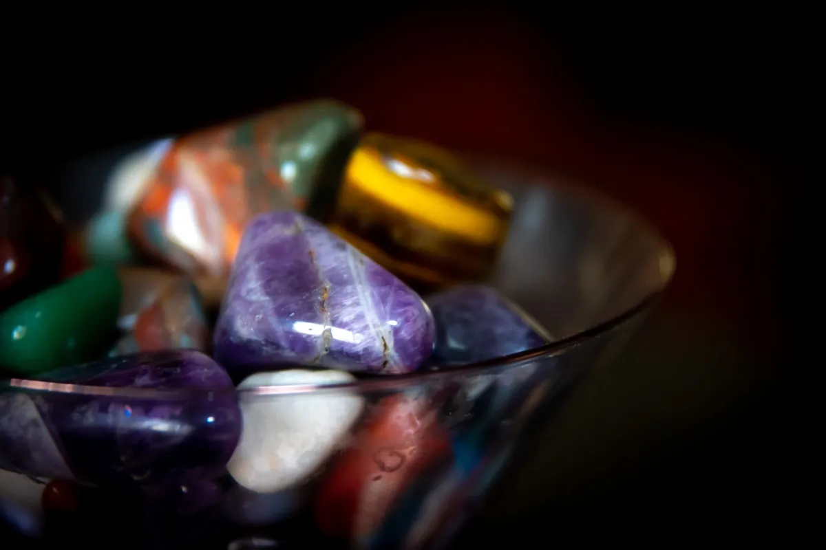 Glossy polished tumbled stones in a glass bowl