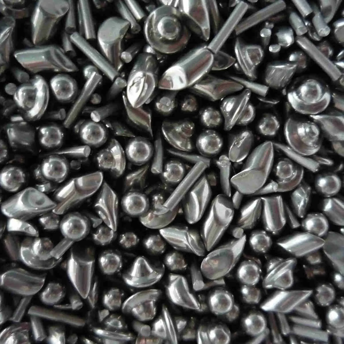 Close-up of stainless steel tumbling shot: angles, balls, cones and pins
